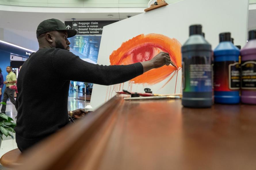 Local artist Mathieu Jean Baptiste paints his first work of art inside Hobby Airport 