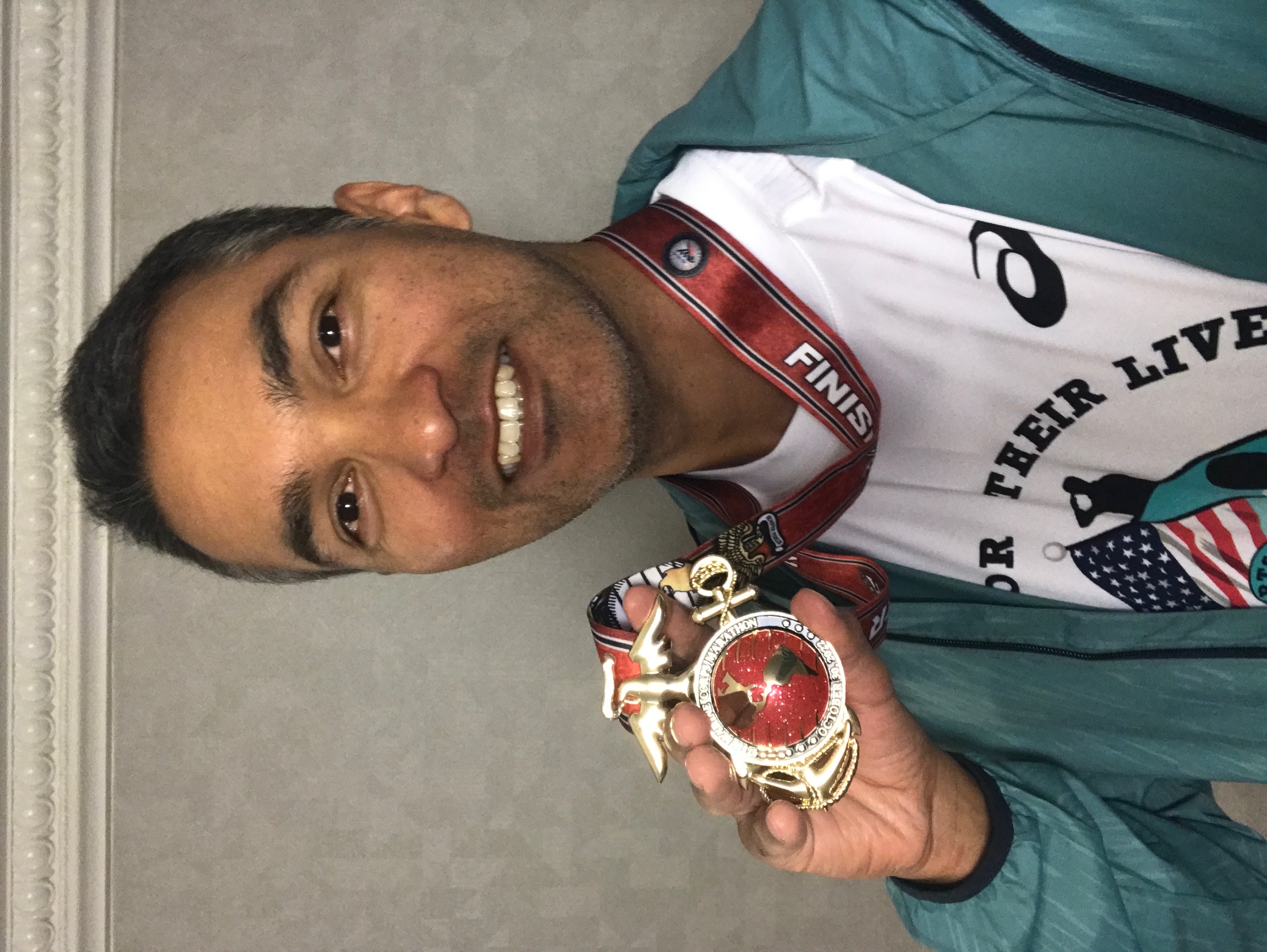 Miguel Ramirez smiles with the Marine Corps Marathon medal
