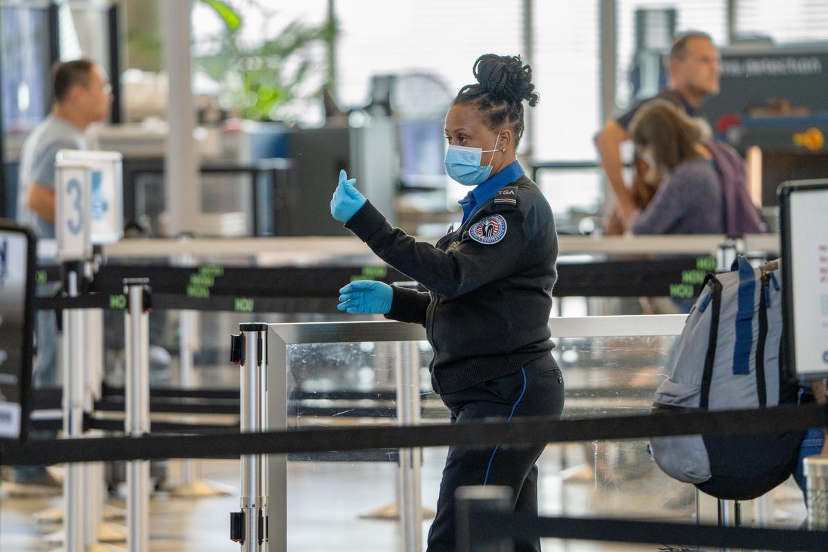 TSA officer signals travelers to approach screening area at Hobby Airport