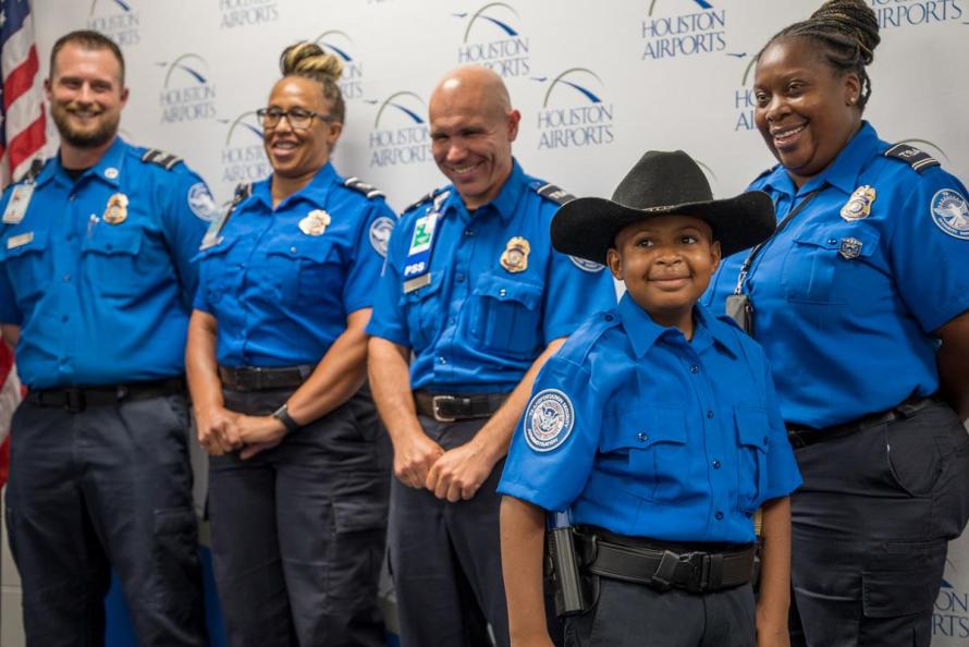 DJ Daniels and his fellow TSA officers are all smiles after the Houston boy is sworn-in as an honorary officer 