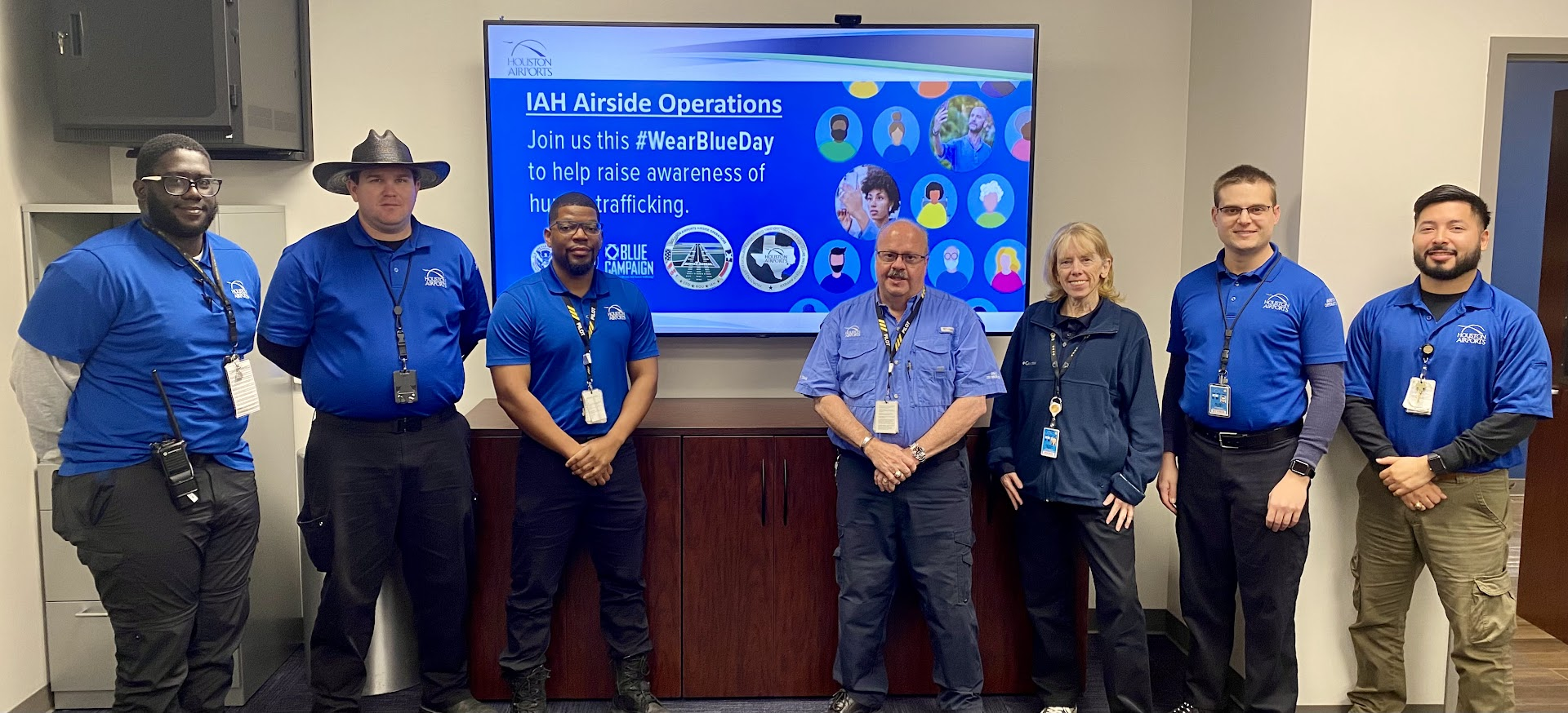  Houston Airports employees pose with TSA and airline representatives, all wearing blue for National Human Trafficking Awareness Day.